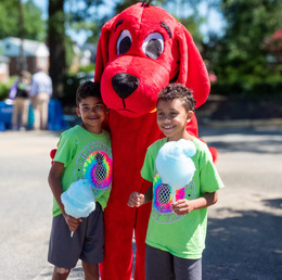 Two Summer Reading Festival attendees pose with Clifford the Big Red Dog mascot. 