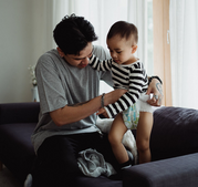 man changing son's diaper