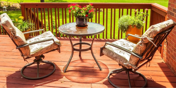 Chairs and a table on a deck outdoors.