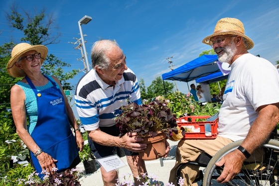three people smiling at a farmers market