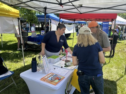 staff member lili helping people at an event table