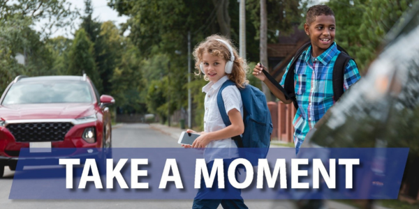 take a moment photo of two children about to cross a road an a car incoming