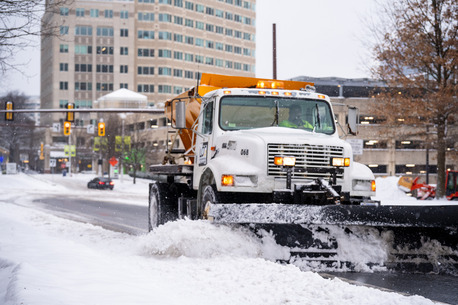 photo of plow cleaning up snowy roadway in reston