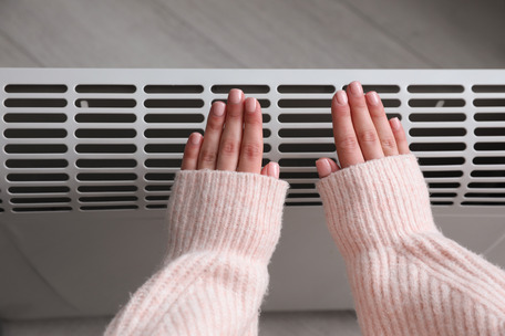 photo of hands in front of a heater