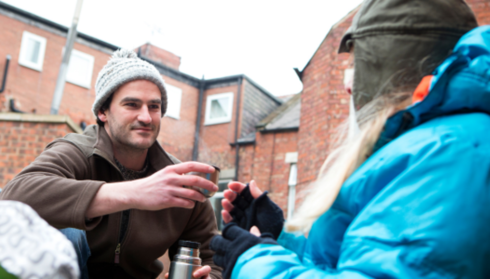 Two people share a thermos cup. 