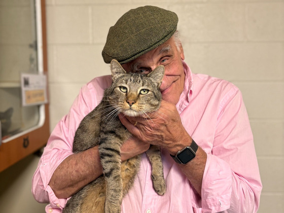 Older man holding a brown cat