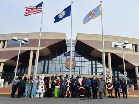 Picture of police officers and Christmas characters in front of the Fairfax County Government Center.