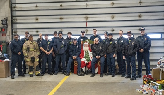 Firefighters smile with Santa.