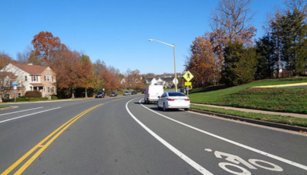 A car driving down a neighborhood road.