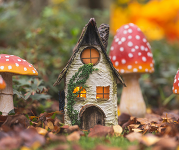 A fairy house surrounded by red mushrooms. 