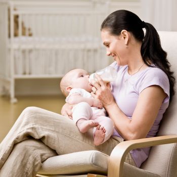 mom in chair holding newborn baby