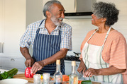 two older adults cooking in the kitchen