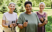 Three older women smile while going for walk outdoors.