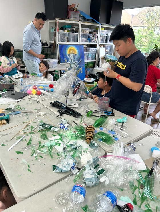 photo of group of kids working with trash to make art. 