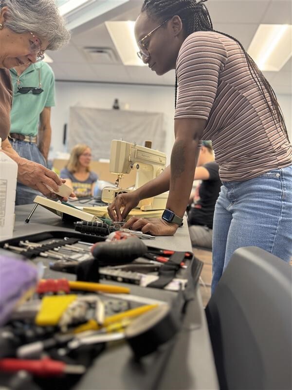 woman helping residents at a fix it clinic. 