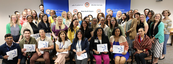 Health Department Staff posing in front of branded banner receiving honors award