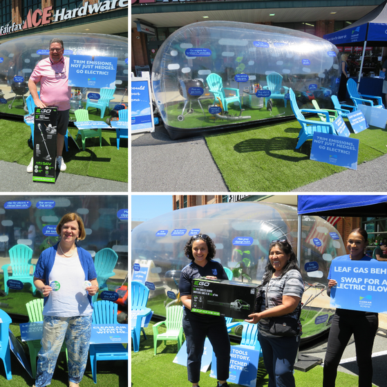 People at an outdoor event promoting electric lawn tools with a clear bubble booth, signs, and prize giveaways.