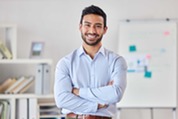smiling man standing with arms folded
