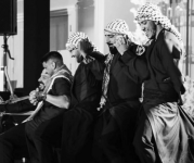 A group of Dabke dancers wearing head scarves and black outfits. 