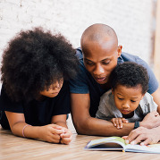 dad reading to sons on the floor