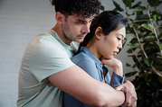 man tightly hugging woman