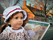 Colonial-era doll in front of historic brick houses beside the book ‘Meet Felicity.’