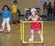 A girl dressed in a Christmas dress and Santa hat roller skating. 