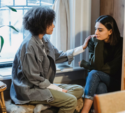 woman comforting another woman