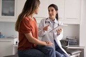 female doctor sitting with female patient