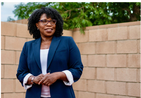 Picture of a black woman oustide in a white shirt and blue blazer