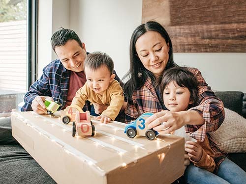 two parents playing cars with children