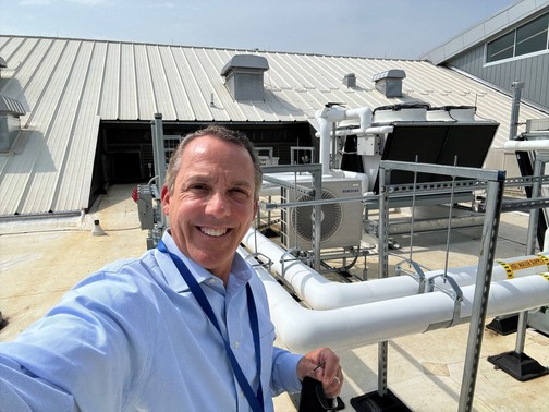 man smiling next to HVAC system