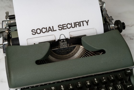 Close-up picture of a vintage typewriter with a sheet of paper loaded that says ‘SOCIAL SECURITY’ in bold letters.