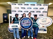 group of women posing in front of VolunteerFest sign