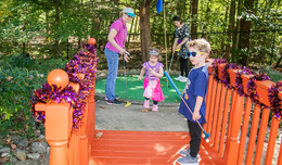 Kids dressed in Halloween costumes play mini golf at Burke Lake Park.