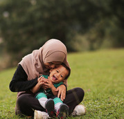 parent and child sitting on the grass