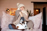 woman bundled up sitting on couch