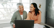 mother and adult daughter sitting at table