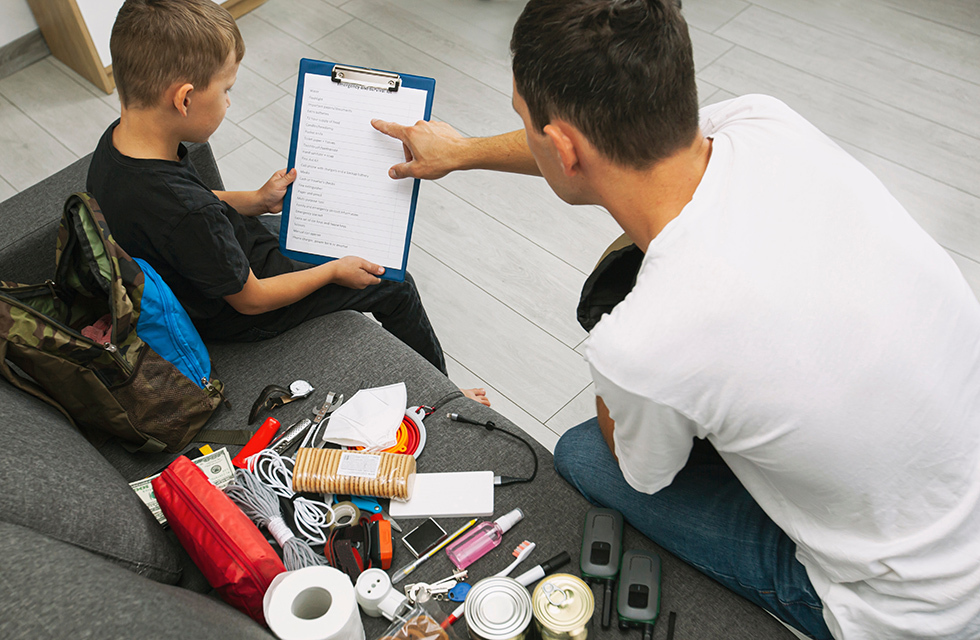 A person helping a child with a emergency checklist.