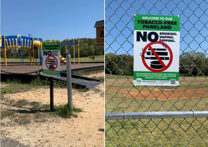 Two tobacco free signs. One at a park and one on a fence.