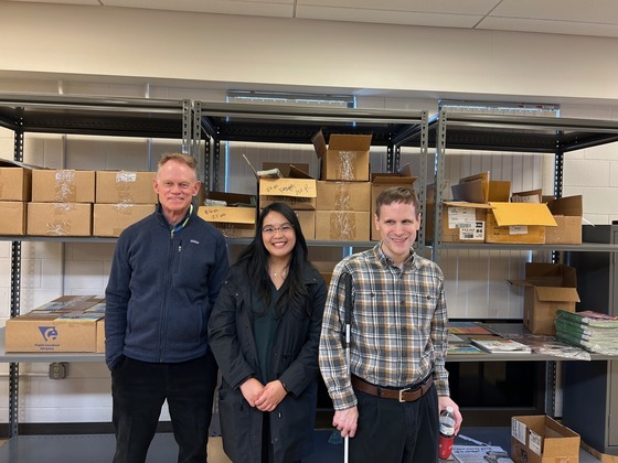 Mark Boldt, Program Manager; Nicole Mayaen, Cessation Coordinator; and Jason Stradone standing in front of shelves with boxes of materials. 