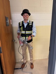 BRHD Director Ryan McKay holding a power tool in the bathroom under construction.