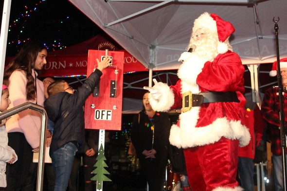 A child and Santa Claus at the tree-lighting ceremony at City Hall in downtown Auburn