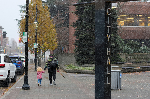 A woman and her child in downtown Auburn as snow began to fall Tuesday, Nov. 29