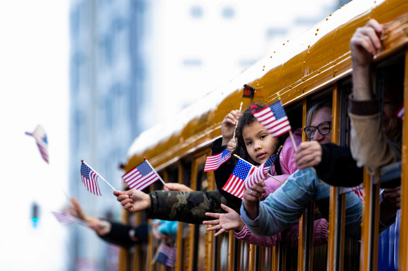 Children on a school bus at Veterans Parade