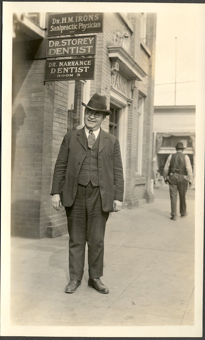 “Sanipractic Physician”, as seen on the sign behind this man taken in downtown Auburn in 1924