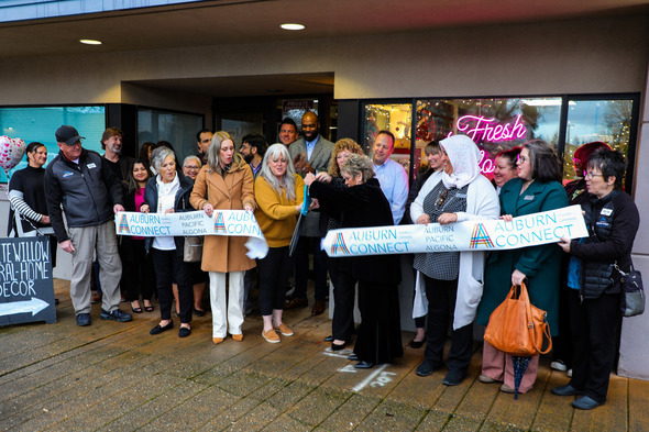 A group of folks cutting a ribbon at White Willow Co. in downtown Auburn