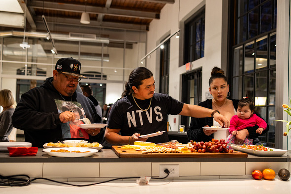 A group of people enjoying a nice spread of feed at the Postmark open house