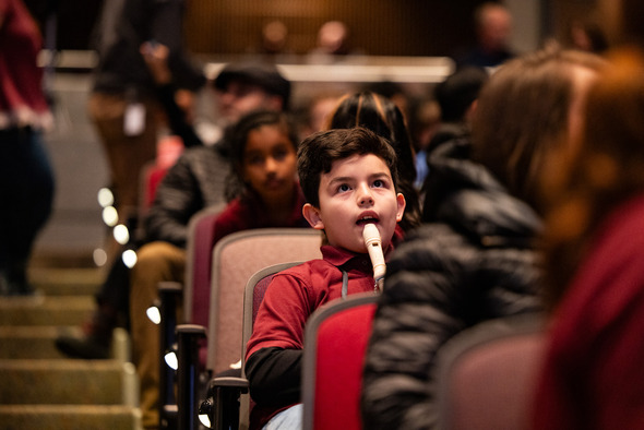 A kid playing a recorder