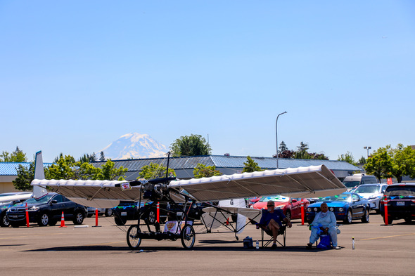 Two people lounging by their cool plane with Mt. Rainier in the background